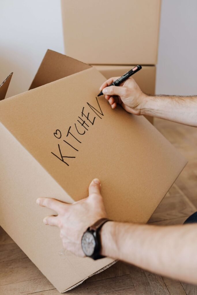 Cardboard Box with "Kitchen" Written in pen on the side.